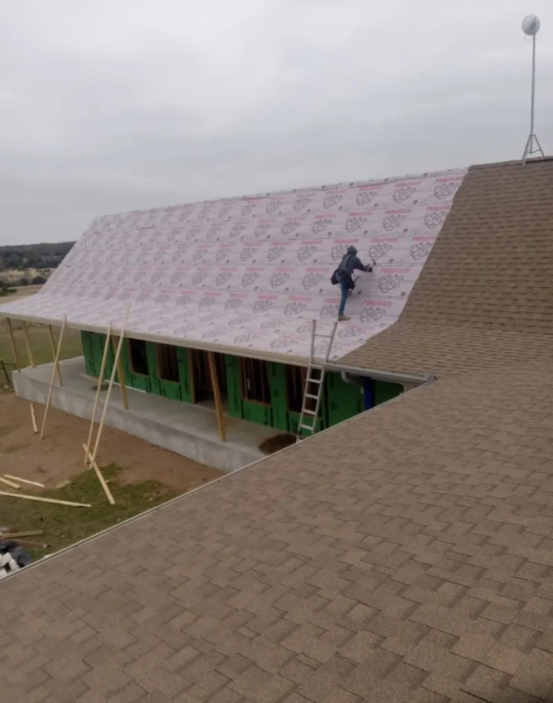 Worker preparing underlayment for a metal roof installation in Summerlin South